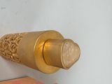 a gold vase that is sitting in a box on a table
