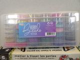 a plastic container filled with lots of beads on top of a table