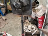 un ventilateur posé sur un support dans un garage