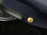 a blue hat with a gold button on top of it