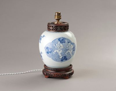 une image représentant un vase bleu et blanc posé sur un socle en bois