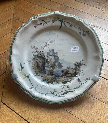 a plate with a painting on it sitting on a wooden floor