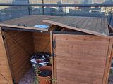 un abri en bois dont la porte est ouverte côté rue