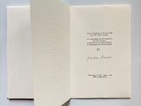 an open book with a piece of paper on top of it