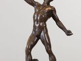 bronze statue of a man holding a baseball bat and a ball