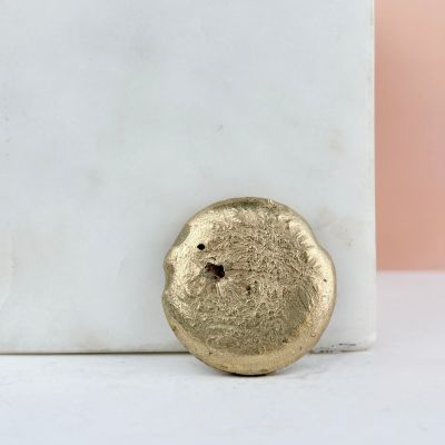 a close up of a gold ring on a white marble block