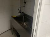 un évier en acier inoxydable dans le coin d'une salle de bains