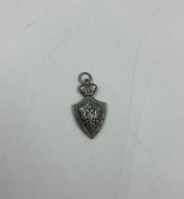 un petit pendentif en argent orné d'une pierre bleue au centre