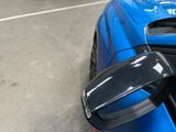 a close up of a blue sports car parked in a parking lot
