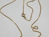 a gold necklace with a chain that has a clasp on it