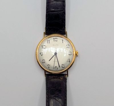 une montre posée sur une surface blanche