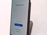 a close up of a cell phone on a stand on a white surface
