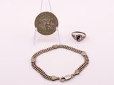 deux bijoux, dont une pièce de monnaie, un bracelet et une bague