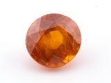 a close up of a yellow sapphire stone on a white surface