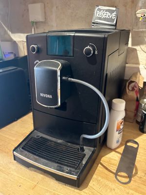 une machine à café noir posée sur une table en bois