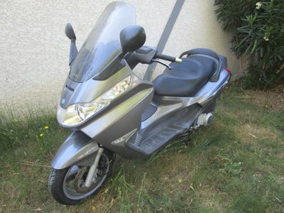 a scooter parked in the grass next to a building