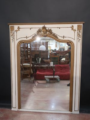 a mirror that is sitting on the floor in front of a red couch