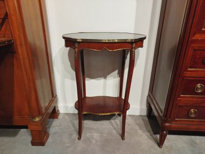 une petite table avec un plateau en verre dans une pièce
