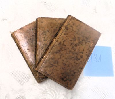 trois portefeuilles en cuir marron posés sur une table blanche