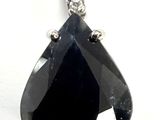 une image représentant un pendentif en forme de diamant noir sur fond blanc