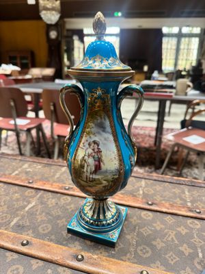 a blue and gold vase sitting on top of a wooden table