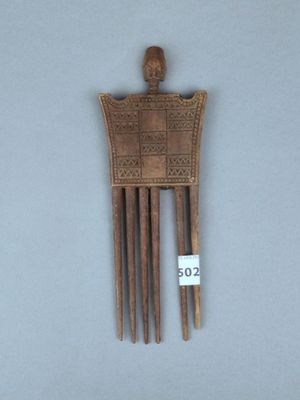 une image représentant un peigne en bois orné d'une tête sculptée