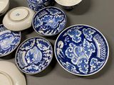 several blue and white plates and bowls are on a table
