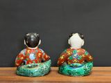 pair of asian figurines of a woman and a man sitting on a table