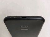 the back of a black cell phone sitting on top of a table