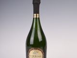 an old bottle of champagne sitting on top of a white table
