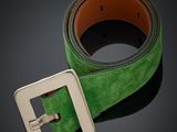 une ceinture verte ornée d'une boucle métallique sur fond noir