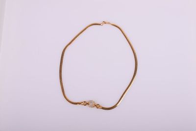 un bracelet en chaîne dorée avec un nœud sur fond blanc