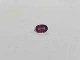 a purple sapphire stone on a white surface