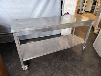 a stainless steel table on wheels in a room