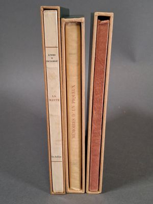 trois livres sont empilés sur une surface grise