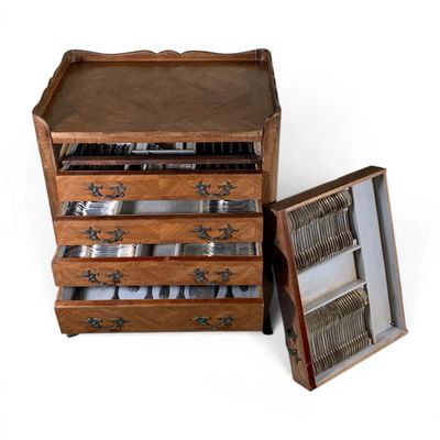 a wooden chest of drawers with silverware in it