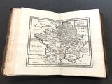 an old book with a map on it sitting on top of a table