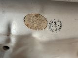 a close up of a white porcelain object with writing on it