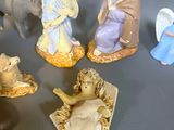 many figurines of people and animals on a table