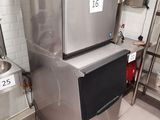 a silver refrigerator in a kitchen with a red bucket on top of it
