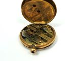 a gold pocket watch inside of it on a white surface