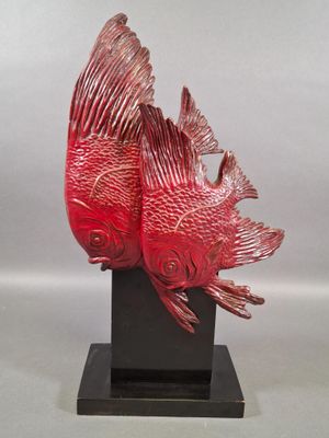 sculpture of two red fish on a black stand