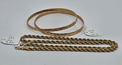 deux chaînes en or et un bracelet en or posés sur une surface blanche