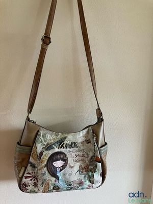 un sac à main accroché au mur, avec la photo d'une jeune fille dessus
