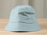 the light blue hat is sitting on a wooden table next to a curtain