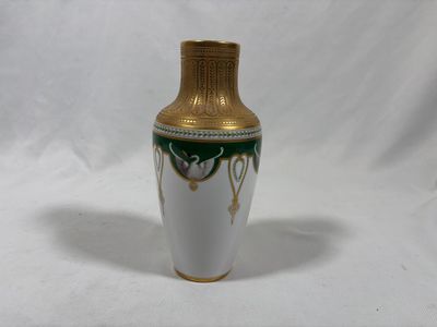 a white and gold vase with a green design on it