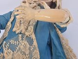 a doll that is wearing a blue dress and holding a doll