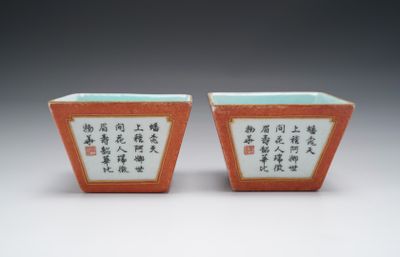 une paire de vases orange et blancs ornés d'inscriptions en chinois