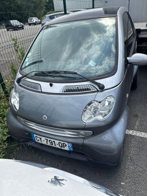 a small car parked in a parking lot next to a truck