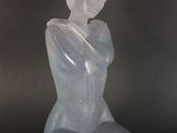 sculpture of a woman sitting on her knees with her hands on her knees